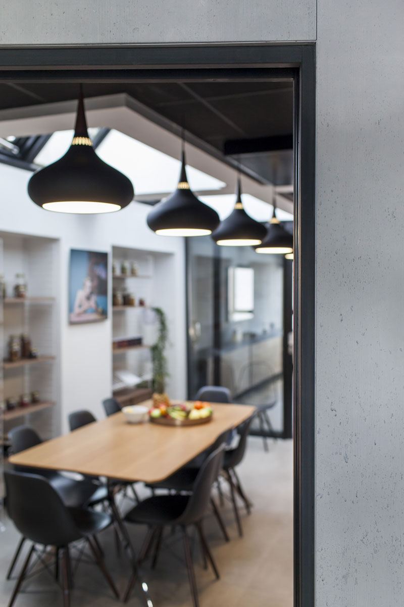 Cuisine et cafétéria Urban Food : grande tablée en bois, suspensions noires et verrière