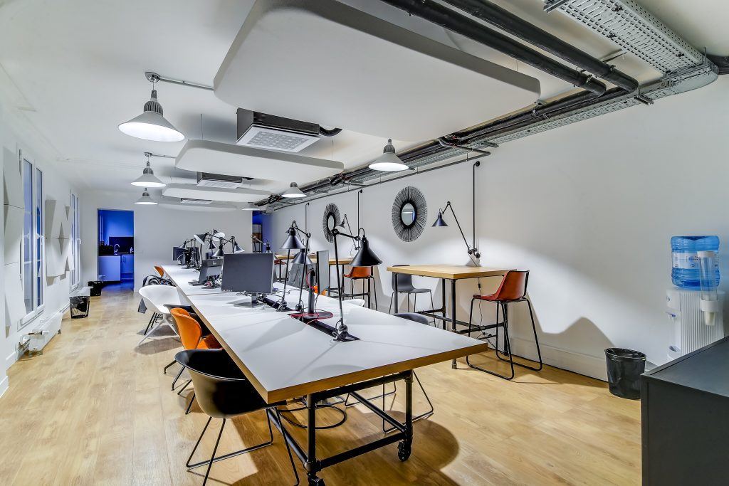 Open space Flexmind aménagé par Isospace, postes en bench et lumière naturelle