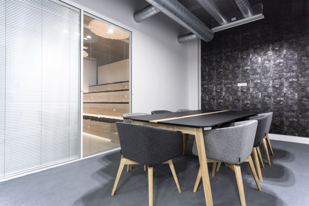 Suspensions acoustiques rondes sous plafond béton noir dans l’espace de coworking Veepee