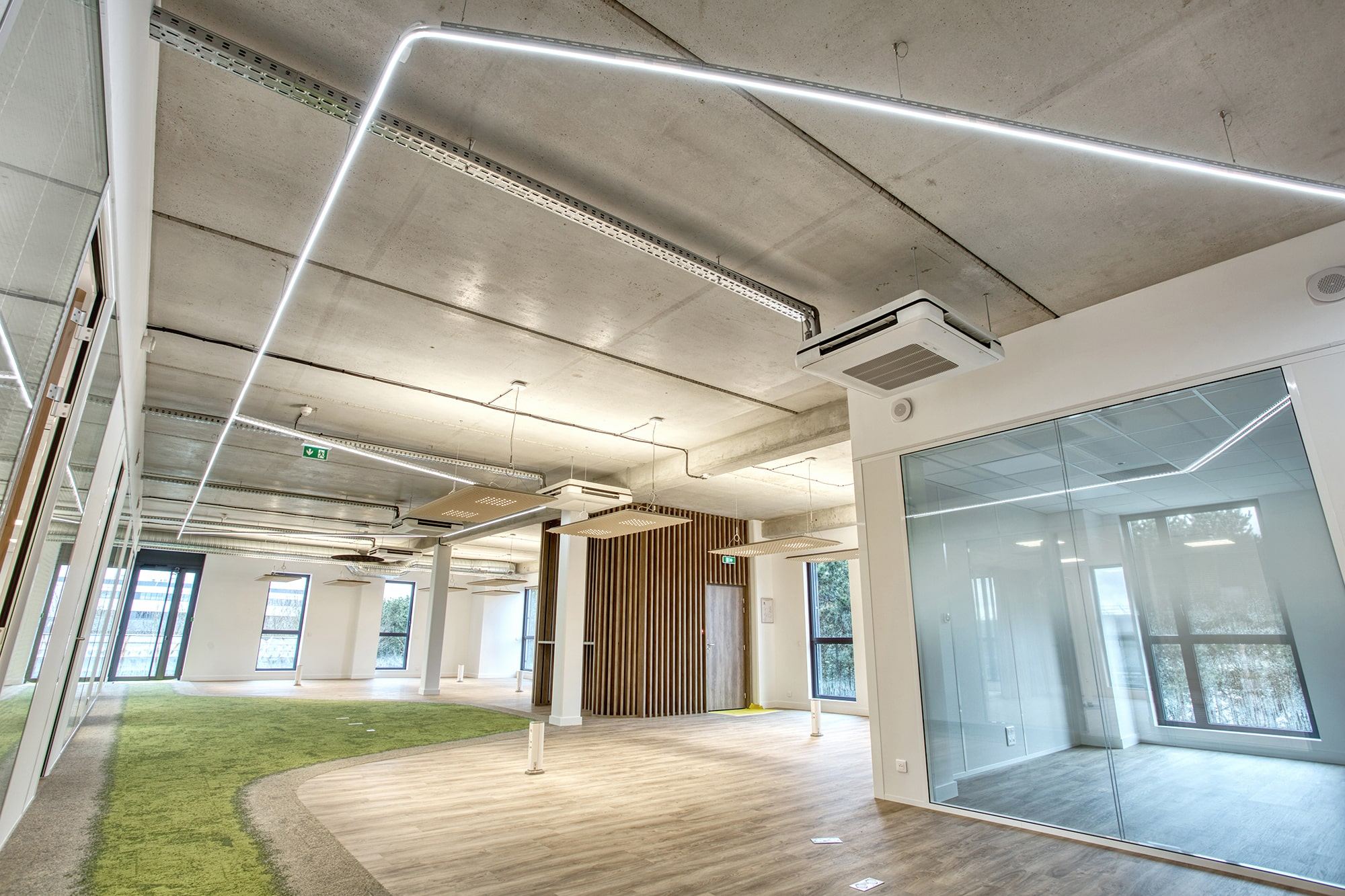 Bureaux Antemeta aménagés par Isospace : open space industriel avec plafond acoustique, mobilier bench et moquette graphique - exemple de projet livré dont le cahier des charges détaillait acoustique, finitions et flux