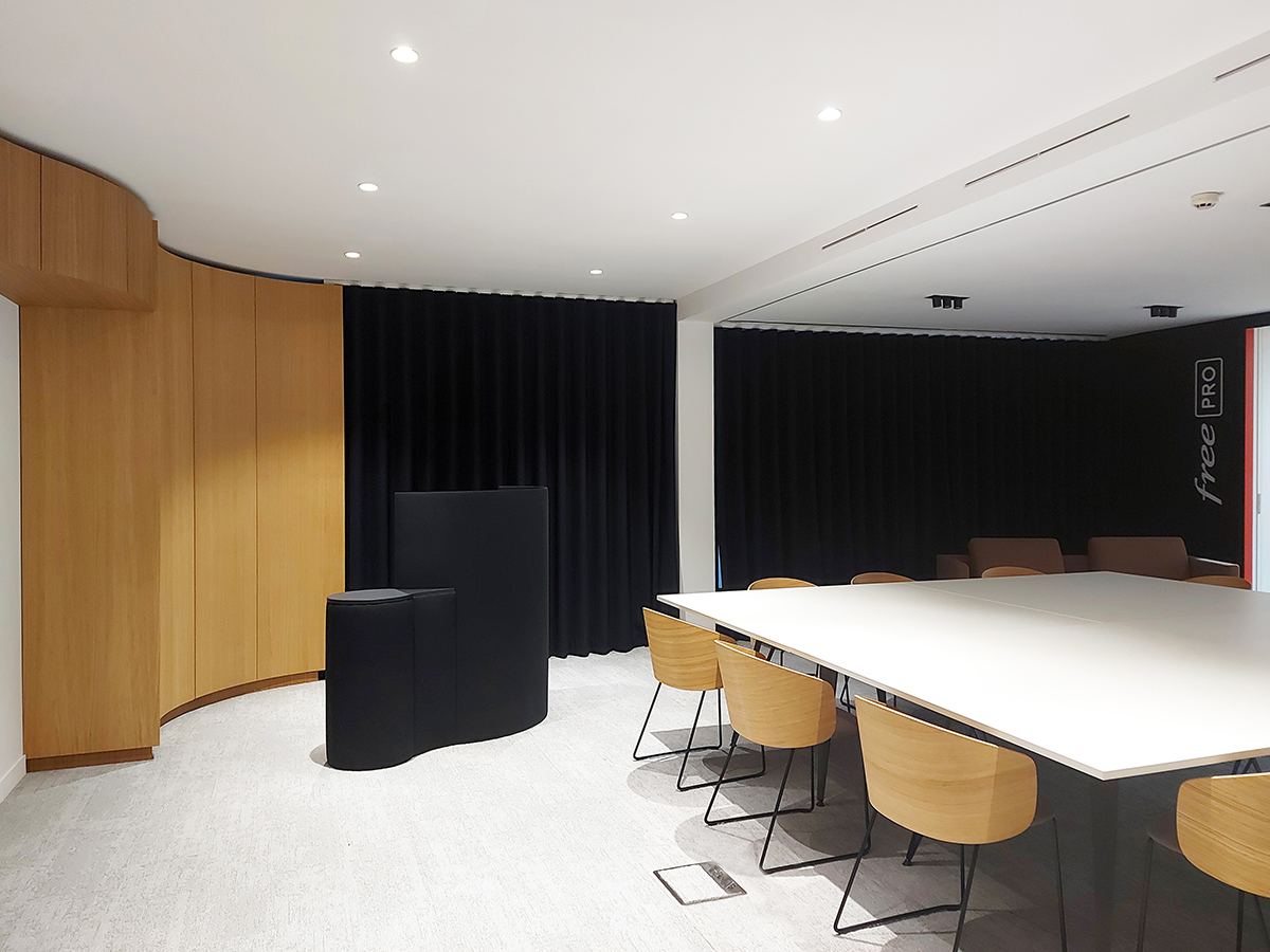Espace théâtral à rideaux noirs du showroom Free PRO
