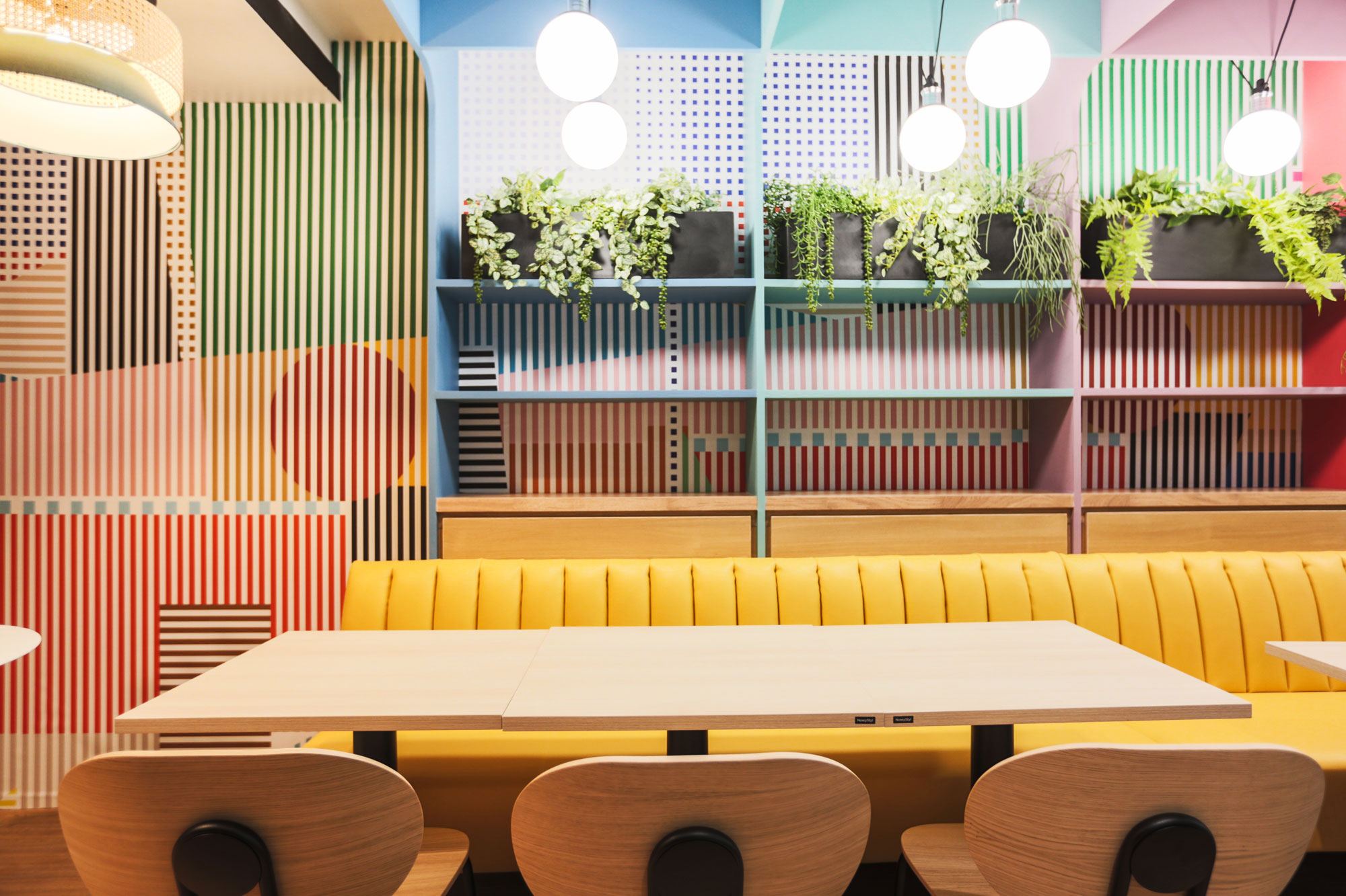 Banquette jaune et mur graphique de la cafétéria Trax
