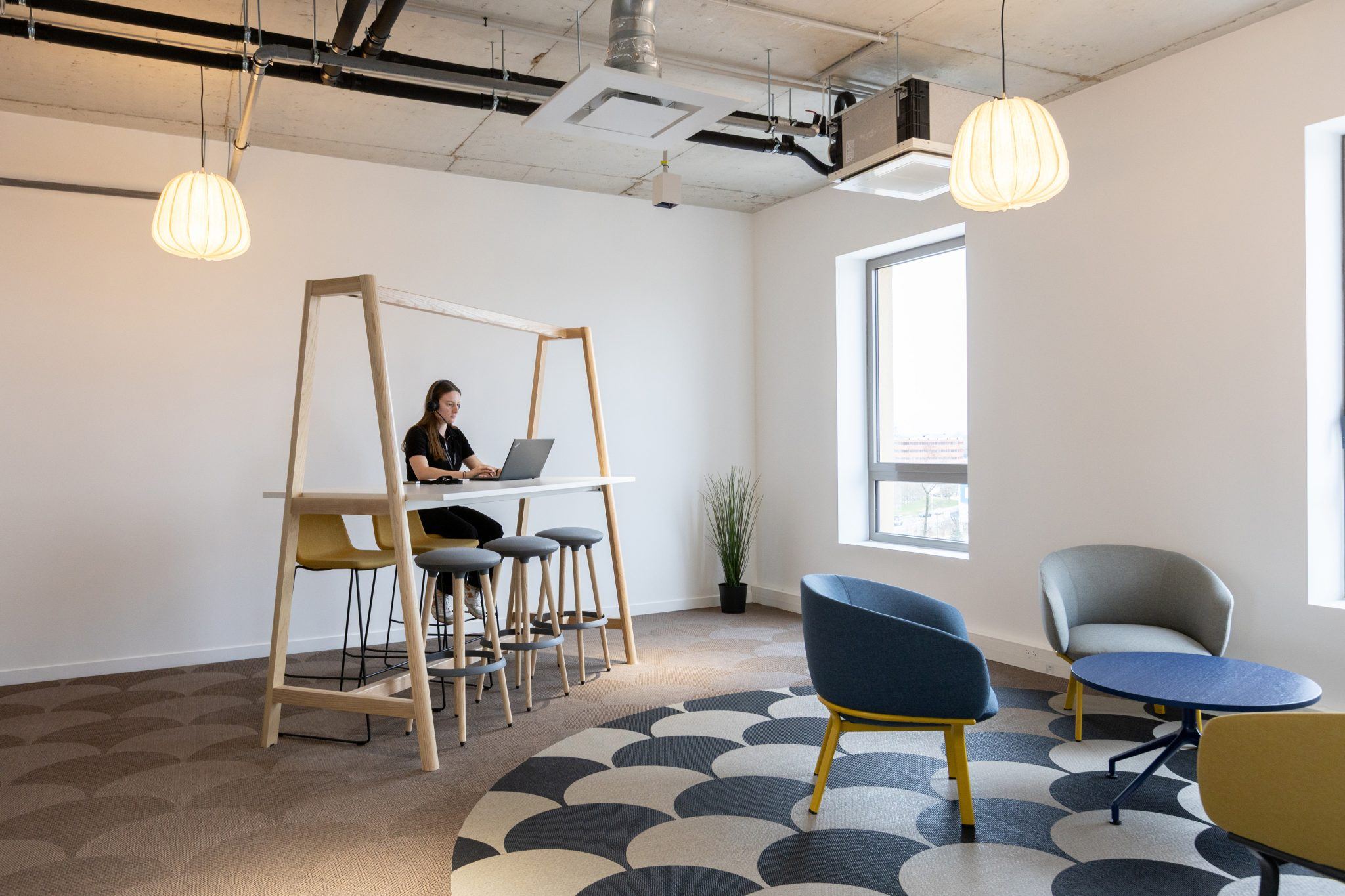 Mange-debout, fauteuils lounge et table basse dans des bureaux aménagés par Isospace