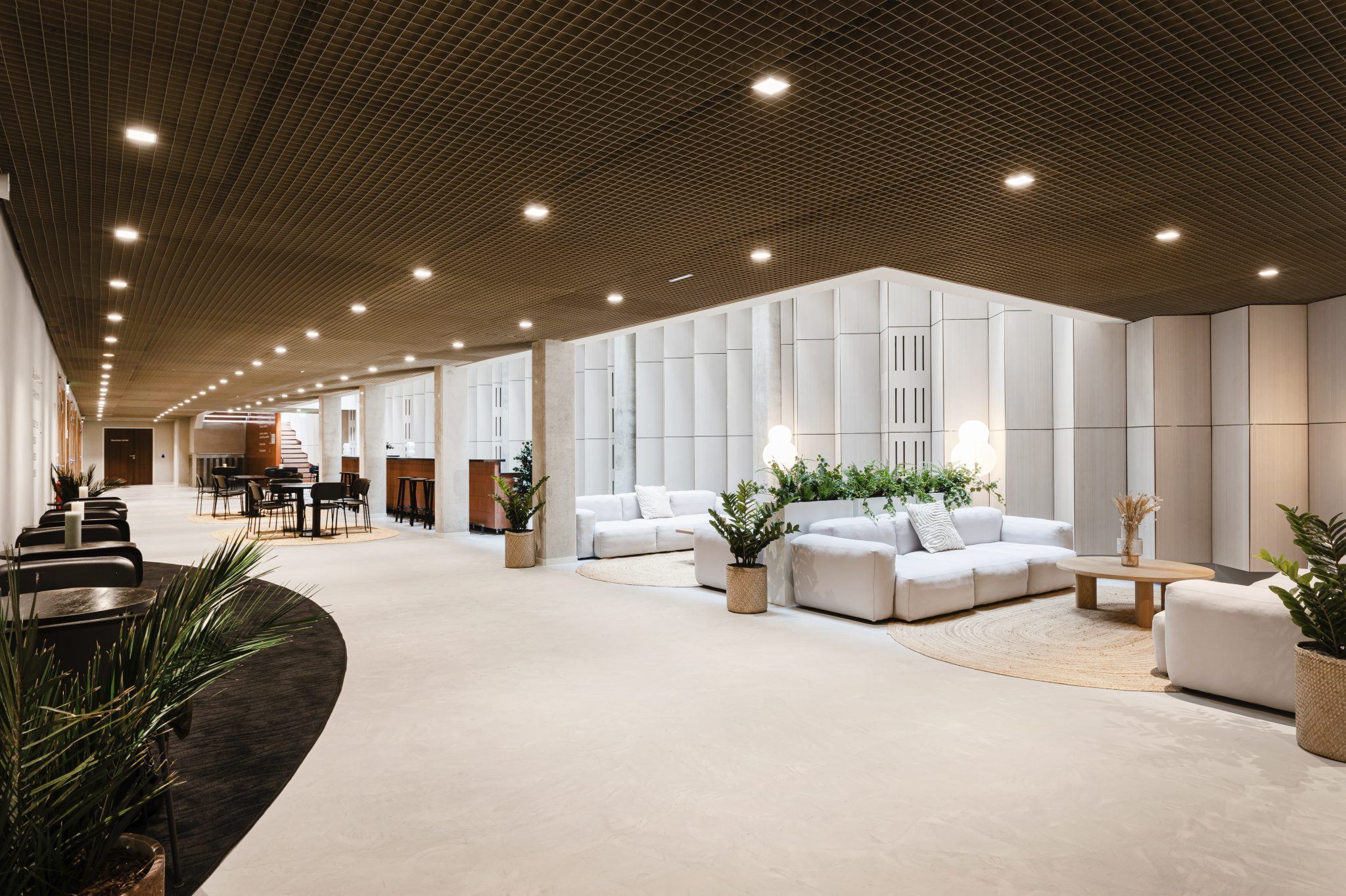 Circulation-lounge meublée en canapés modulaires et tables dans des bureaux aménagés par Isospace