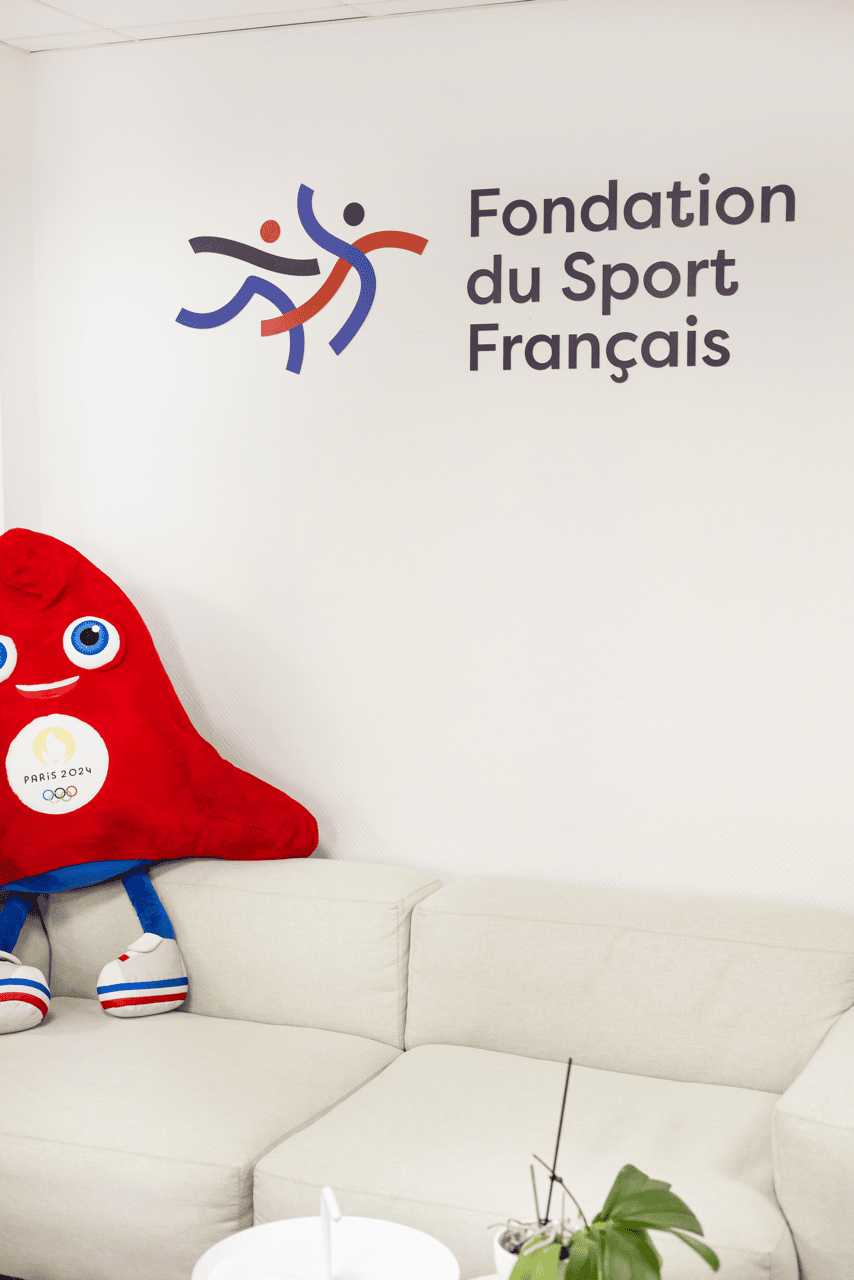 Accueil du siège de la Fondation du Sport Français avec logo mural et mascotte
