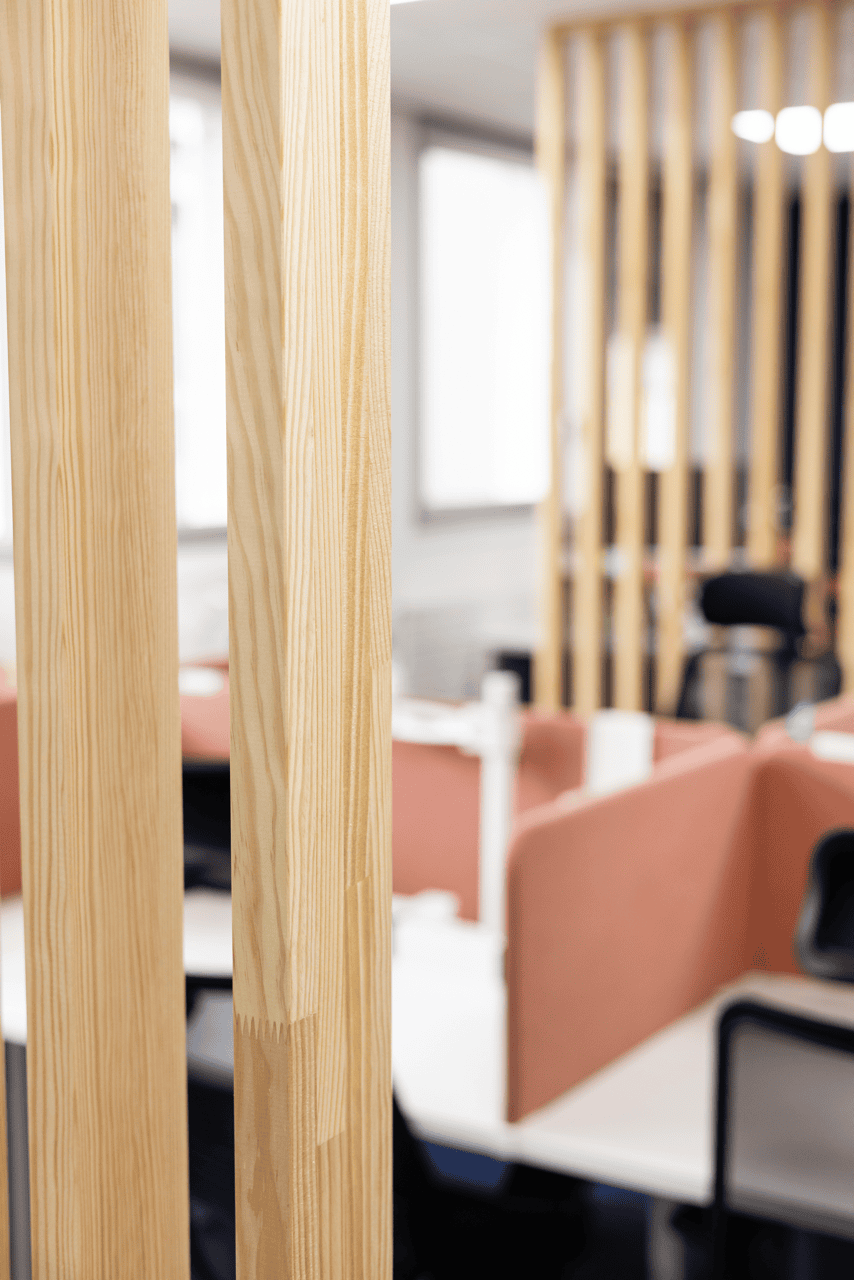 Claustra en bois clair structurant l'open space