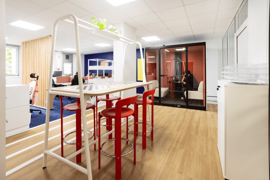 Coin café à mange-debout et tabourets rouges, siège de la Fondation du Sport Français