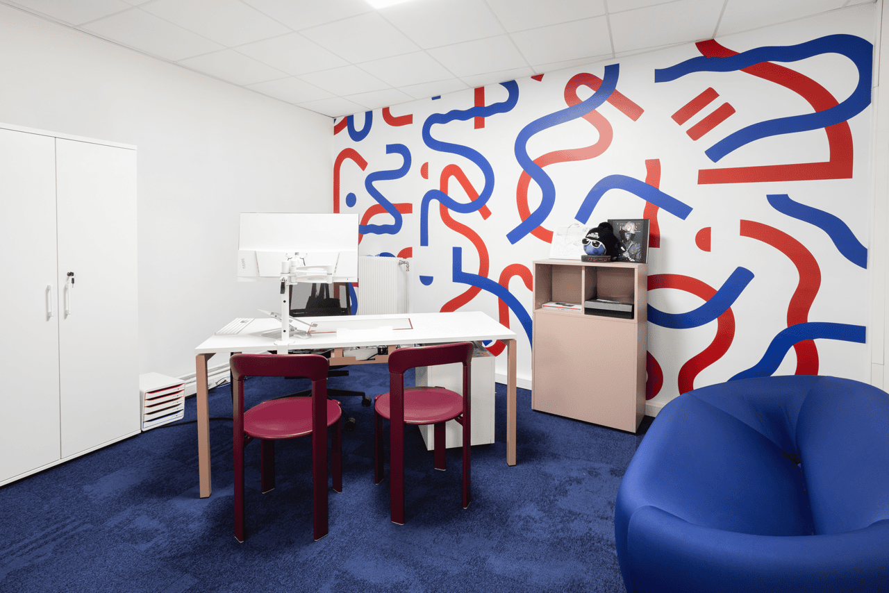 Salle créative avec fresque murale graphique bleu et rouge