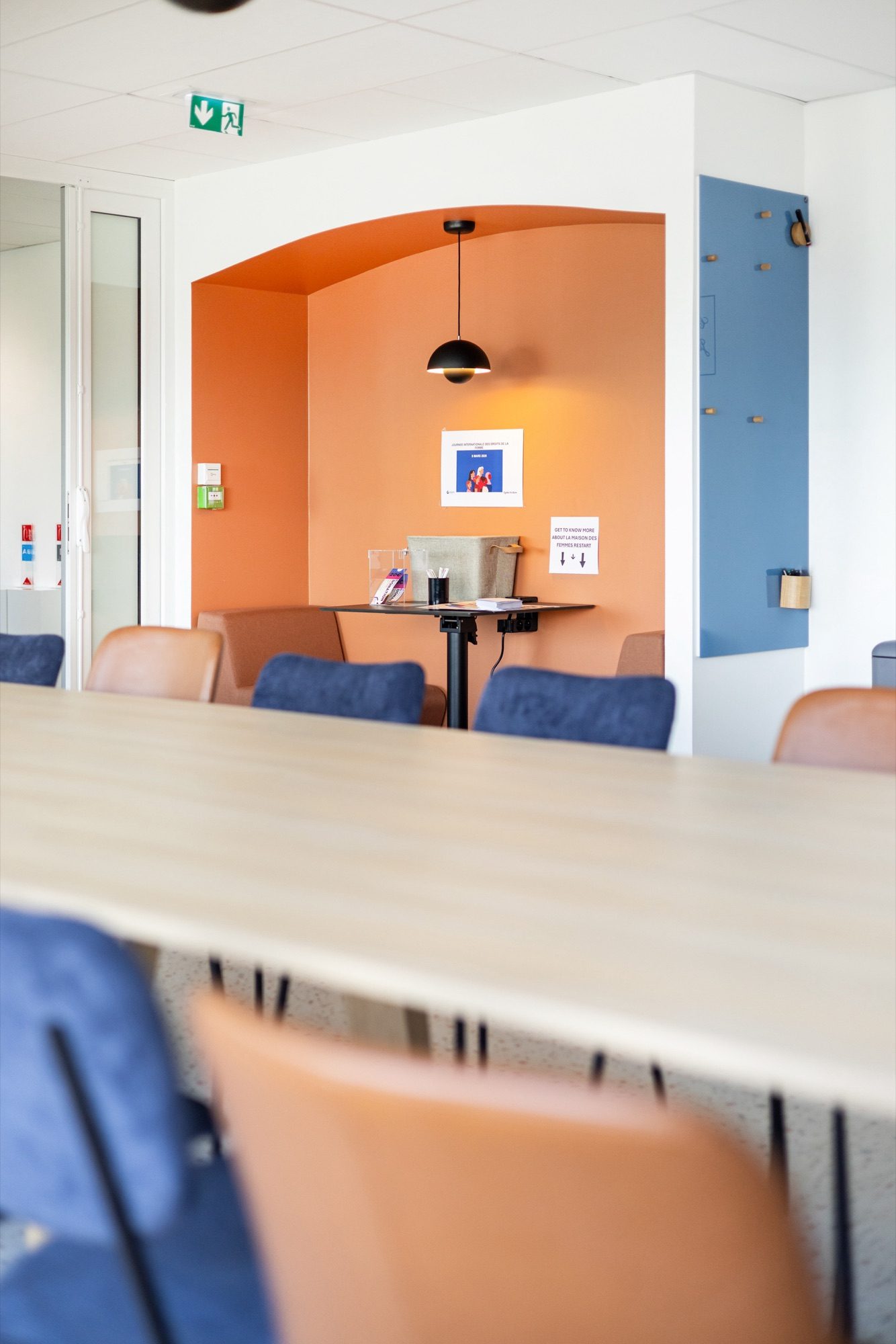 Niche cosy avec arche orange et banquette dans des bureaux pharmaceutiques