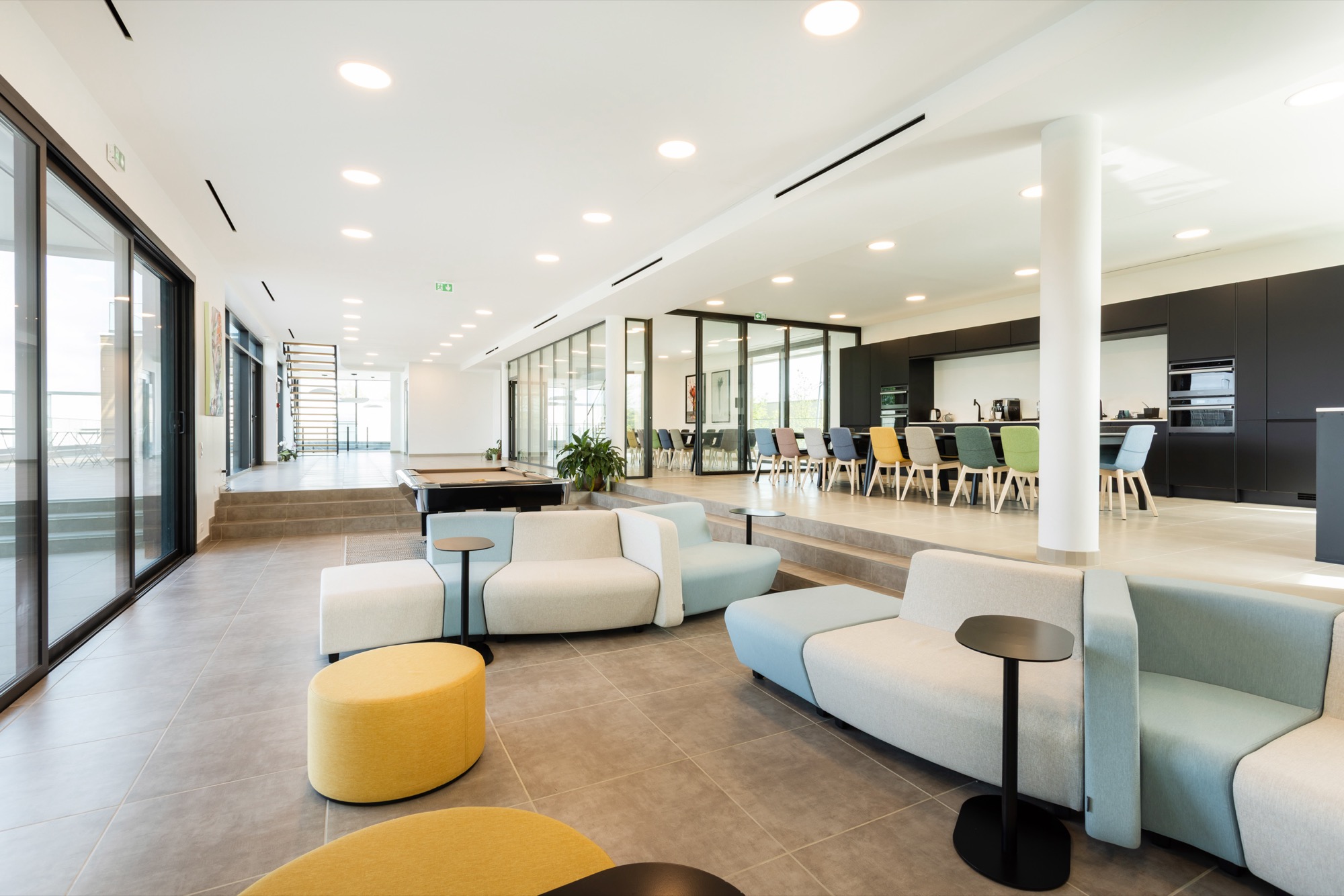 Espace de vie des bureaux SOLPOL : lounge, billard et cafétéria en enfilade