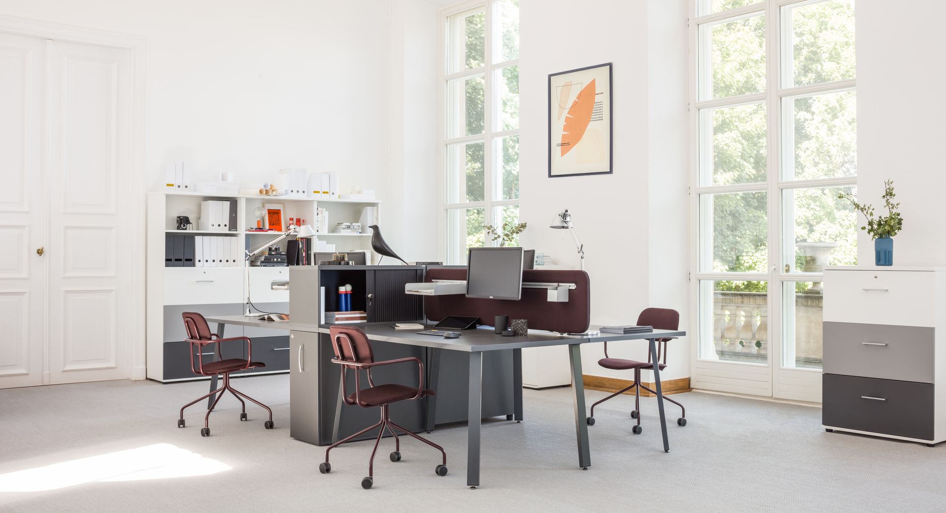 Bureau simple 4 à 6 personnes en bench installé dans un open space avec écrans et séparateur
