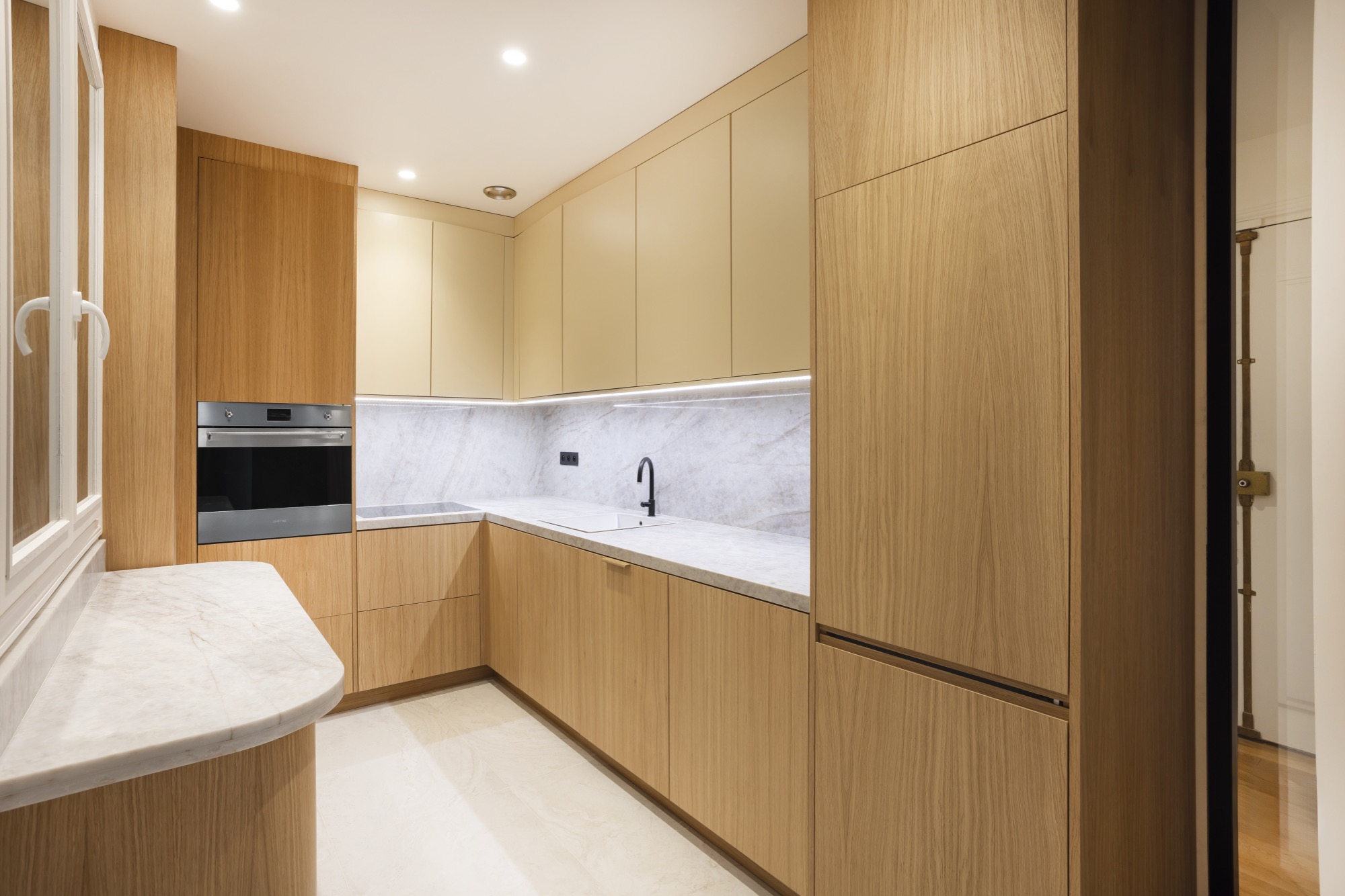 Cuisine sur-mesure en chêne avec plan de travail en marbre, appartement rénové