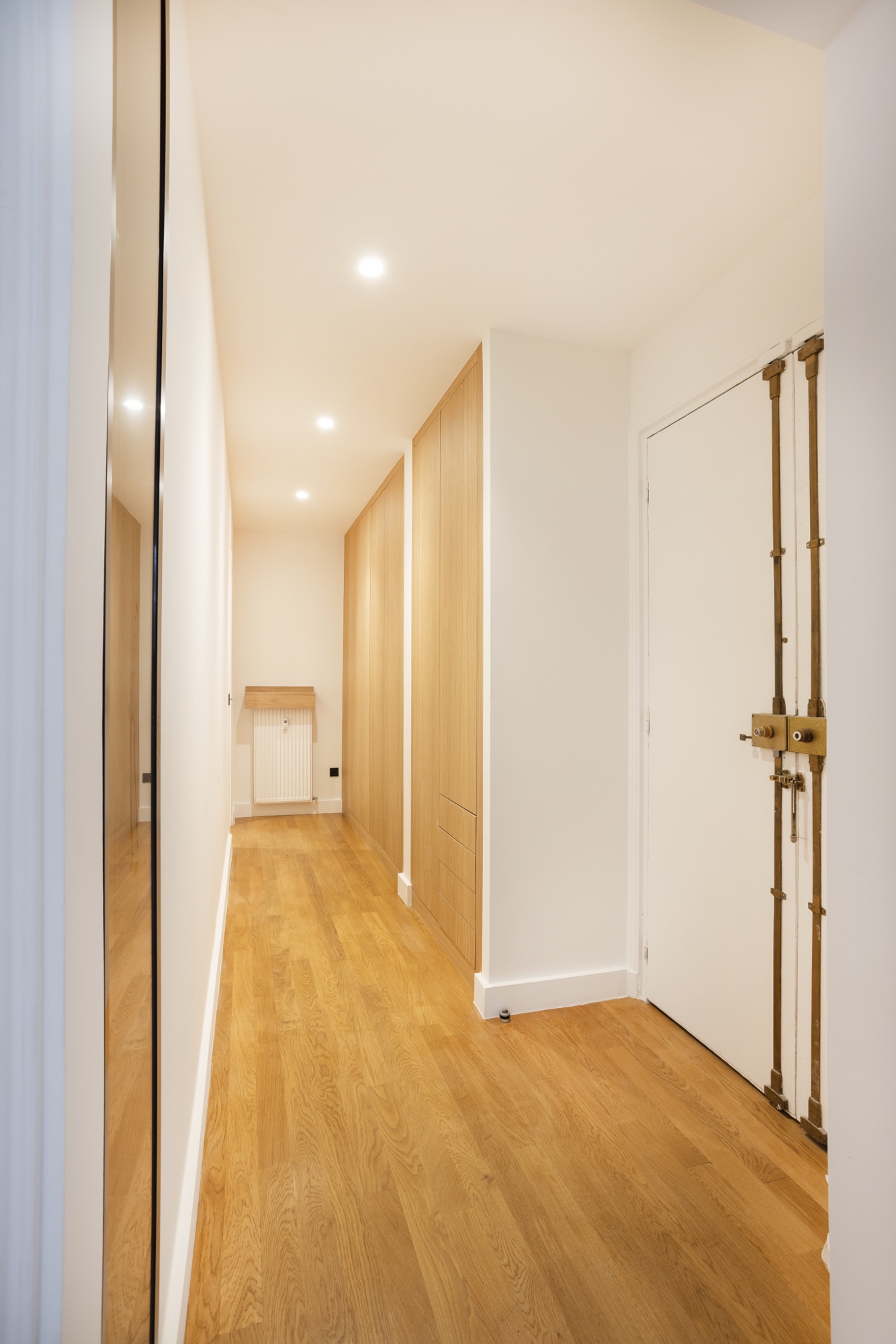 Entrée et couloir avec rangements sur-mesure en chêne et porte palière d'origine