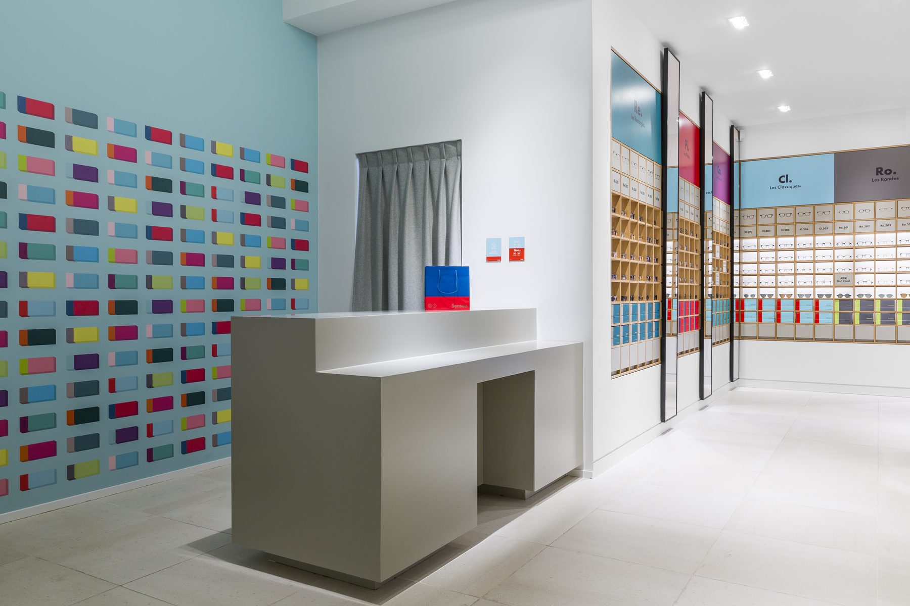 Mur d’échantillons de couleurs et comptoir de la boutique d’optique Sensee