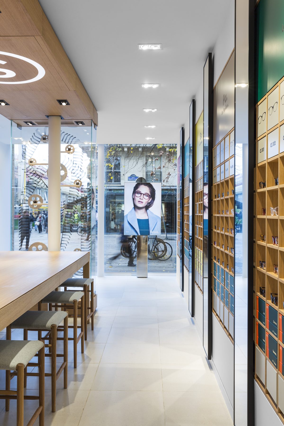 Perspective de la boutique Sensee vers la vitrine, murs de lunettes et sol clair