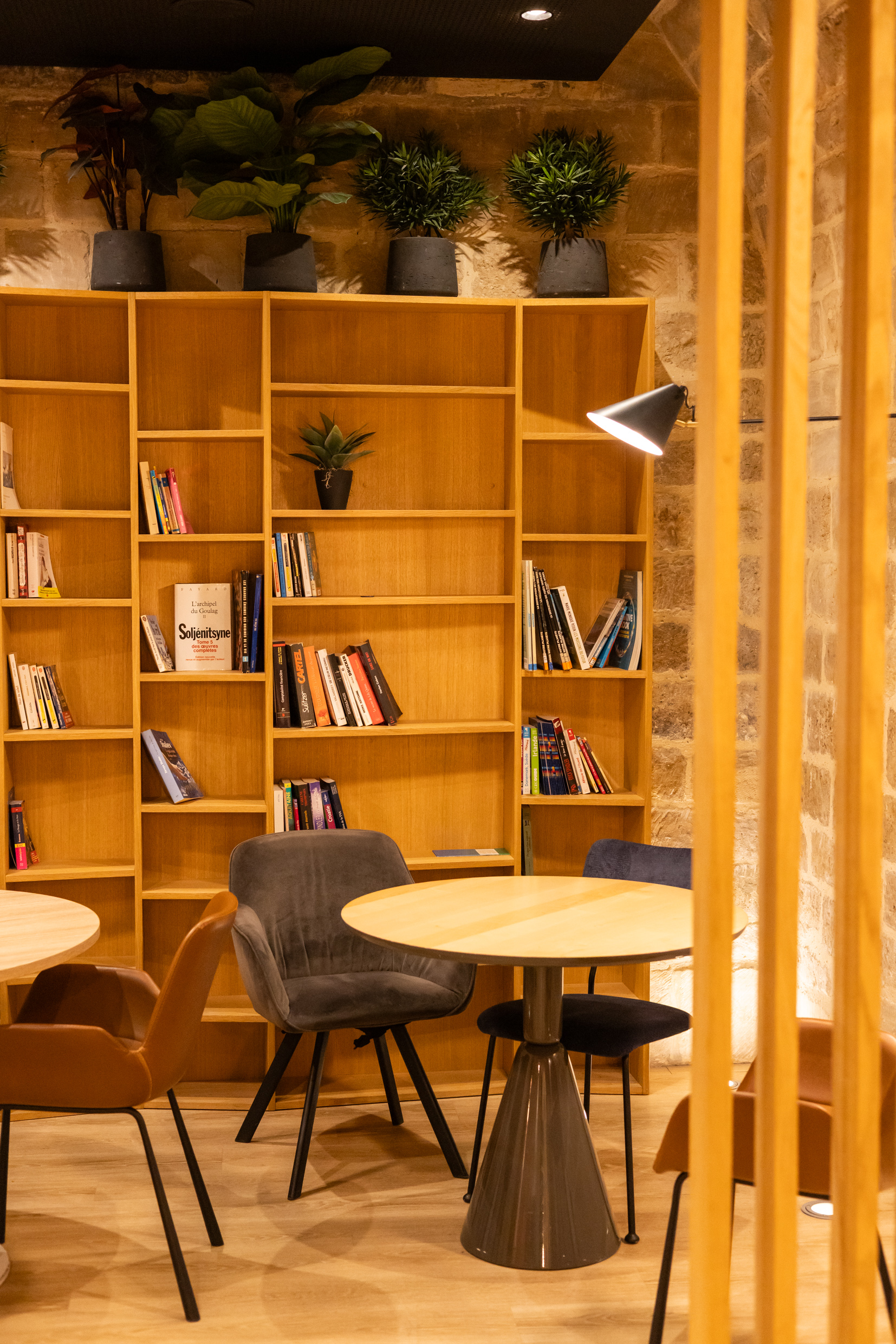 Coin bibliothèque avec fauteuils et étagères en bois, Agora