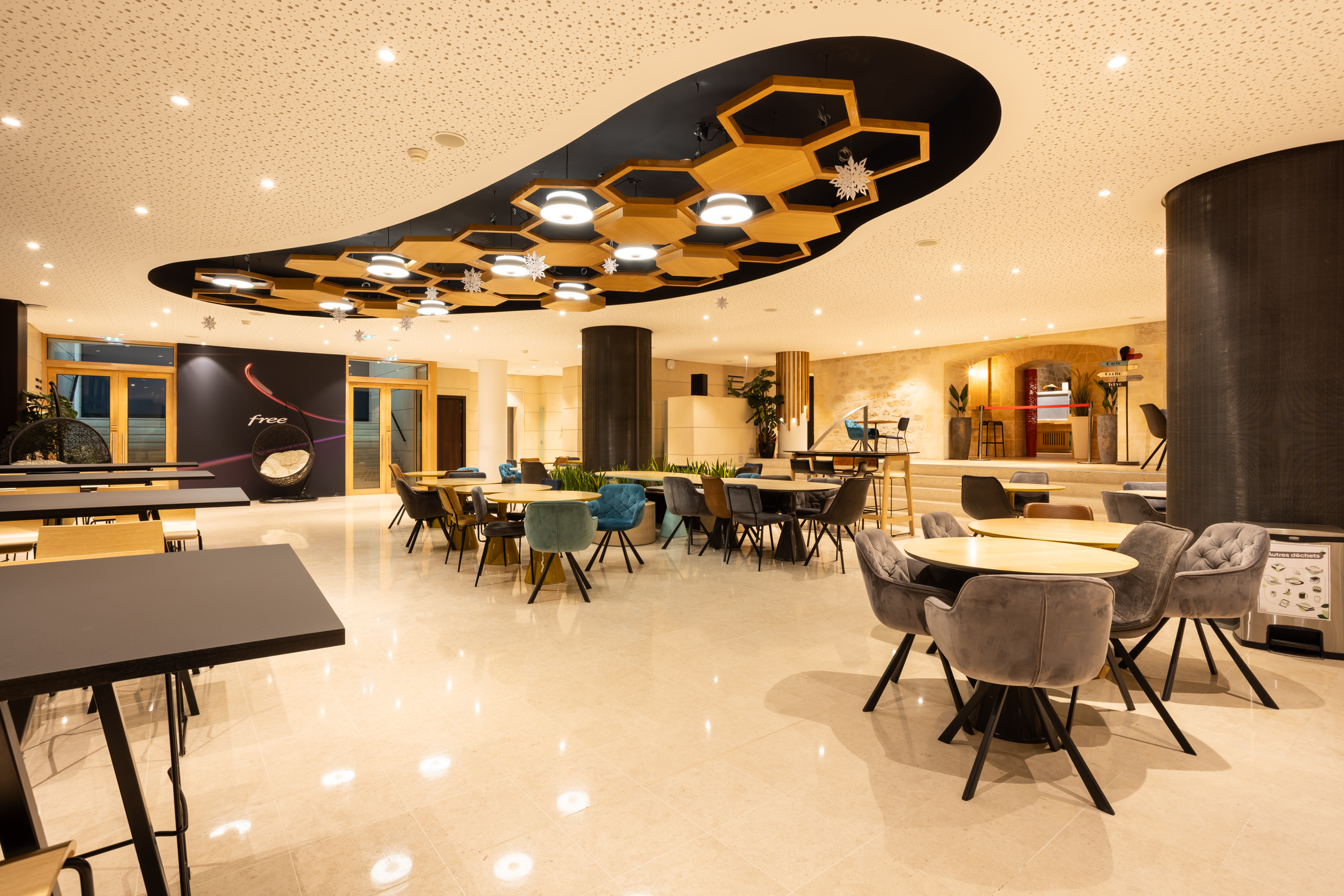 Salle du restaurant d'entreprise Agora de Free : plafond en alvéoles bois et grande salle à manger