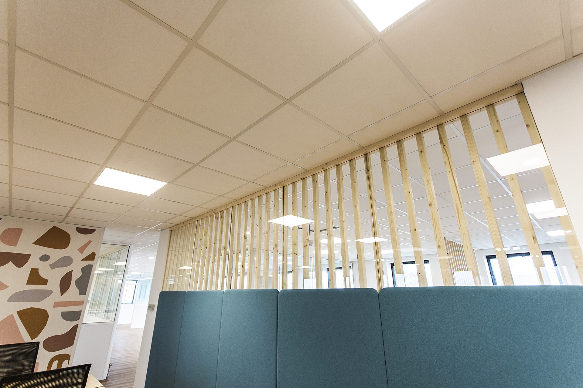 Faux plafond et claustra bois en oblique surplombant les postes de travail