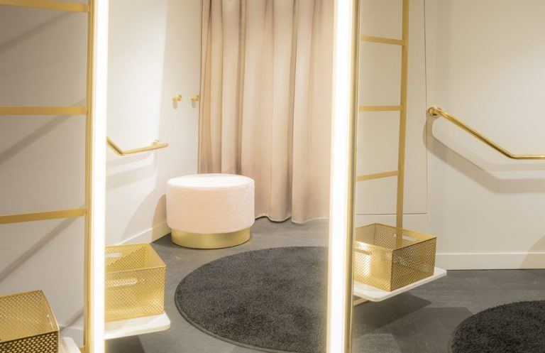 Cabine d'essayage habillée de laiton doré et de velours de la boutique Aubade