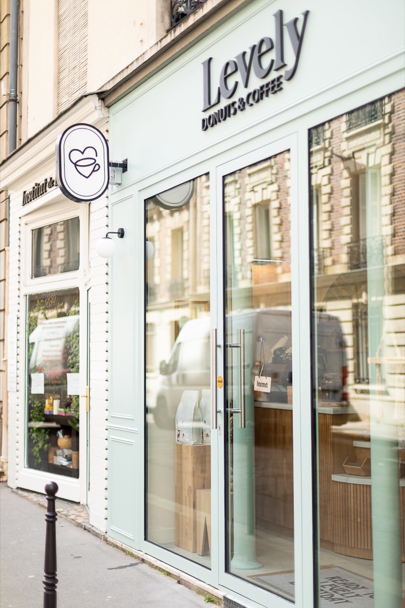 Enseigne drapeau de la boutique Levely avec logo tasse, posée par Isospace