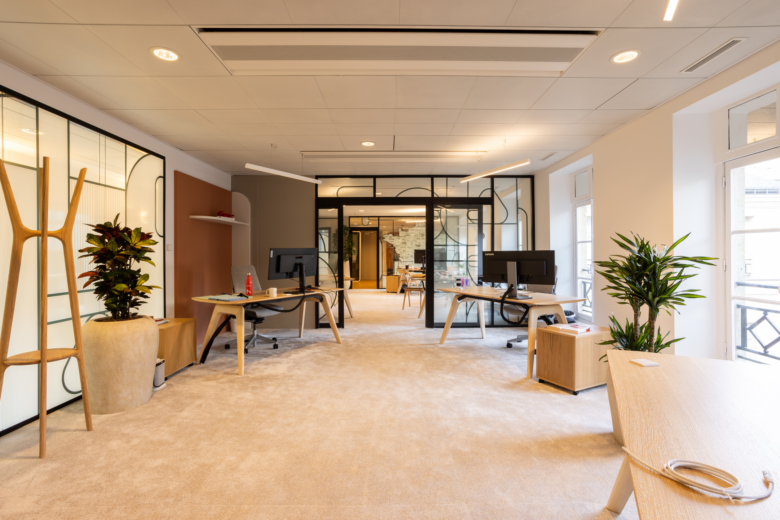 Bureaux de direction d'un groupe télécom : cloisons vitrées à décor graphique, mobilier chêne et plantes