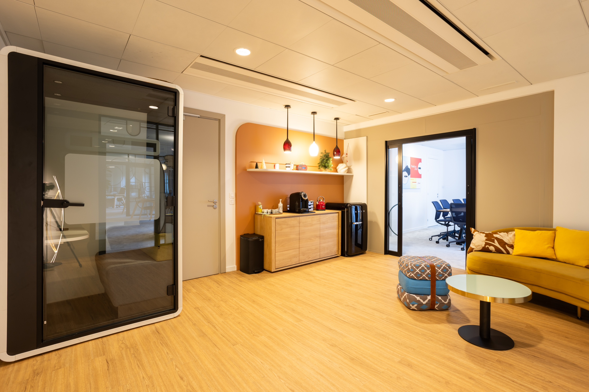 Espace de détente des dirigeants avec phone box acoustique, coin café et canapé jaune