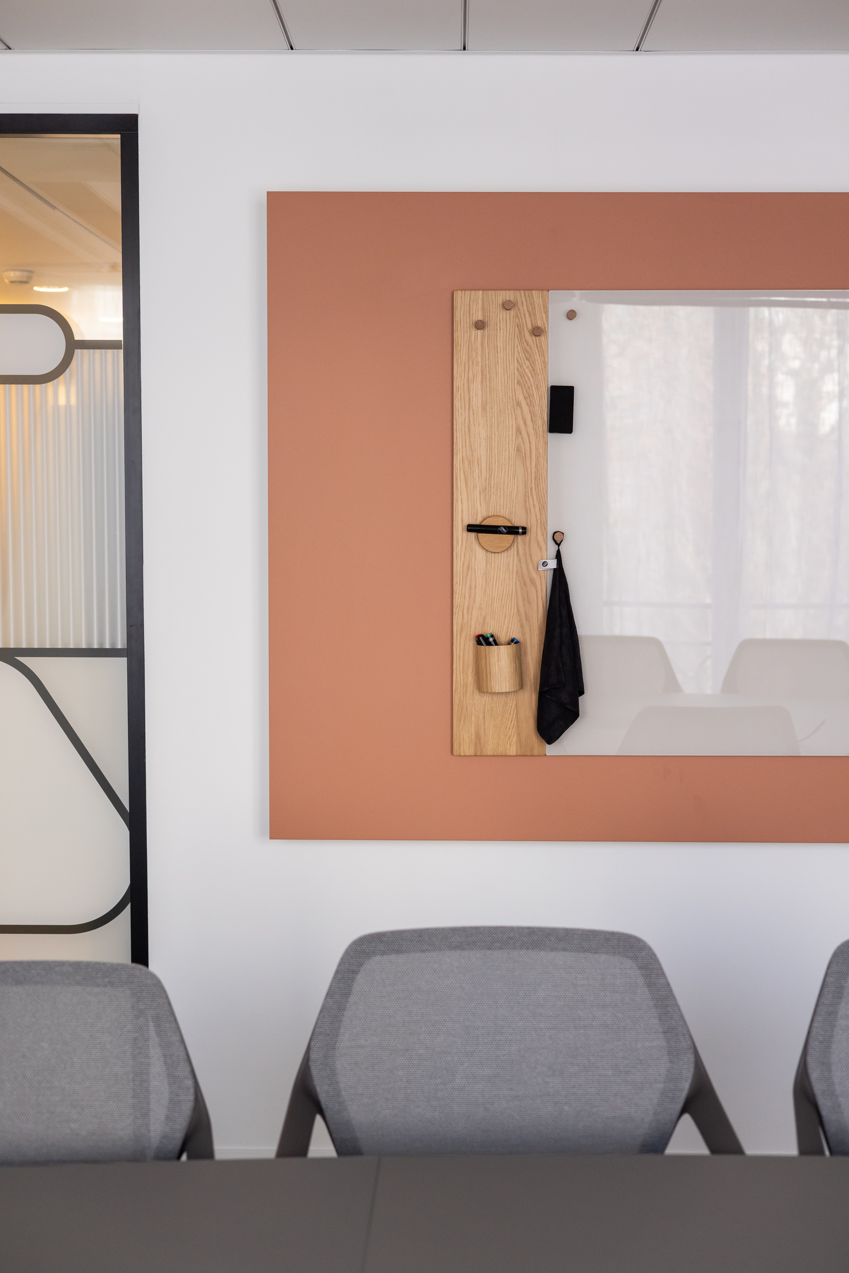 Détail d'une salle de réunion : panneau terracotta et tableau en chêne sur-mesure