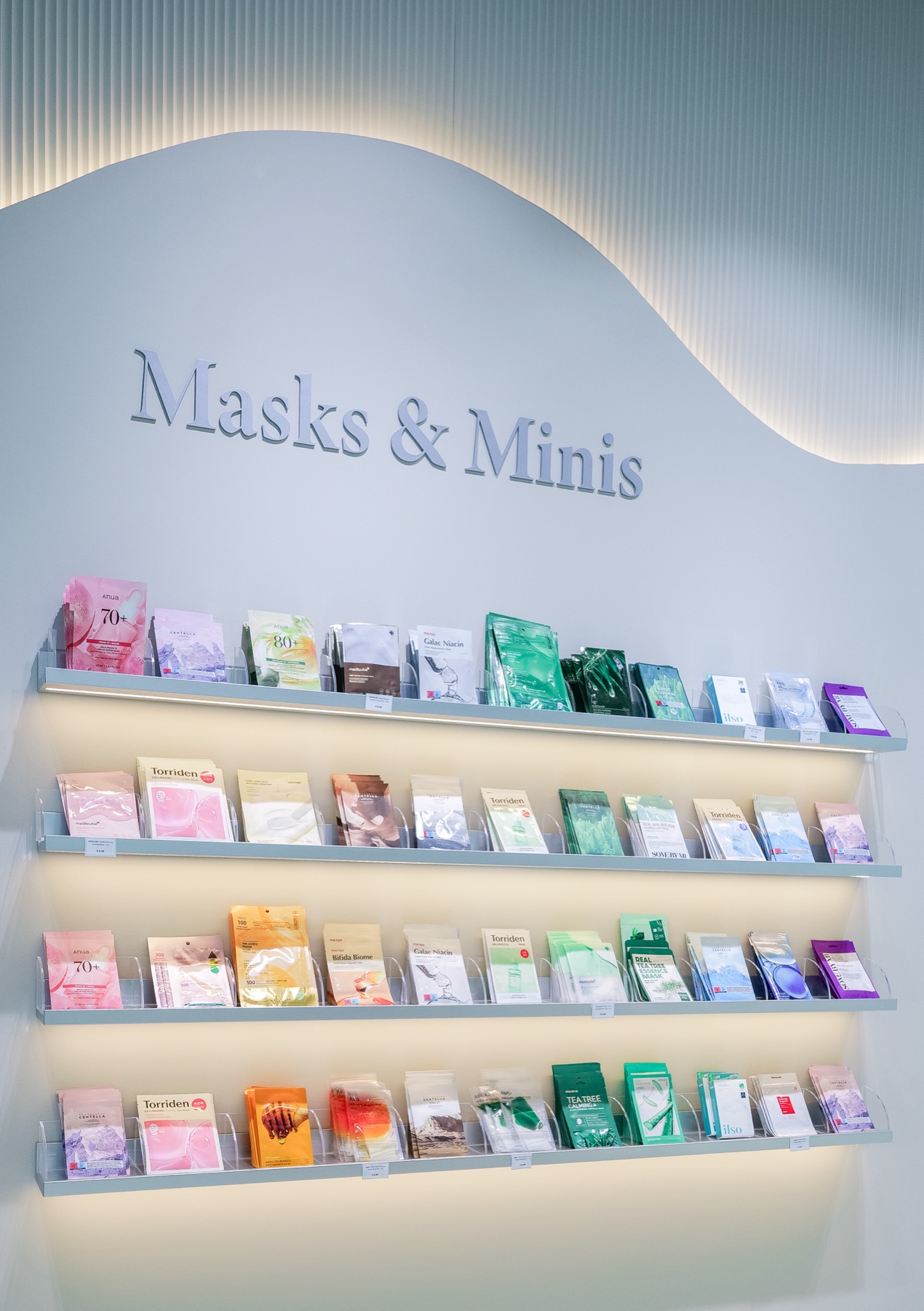 Mur de masques de la boutique Joo Beauty, étagères inclinées rétroéclairées