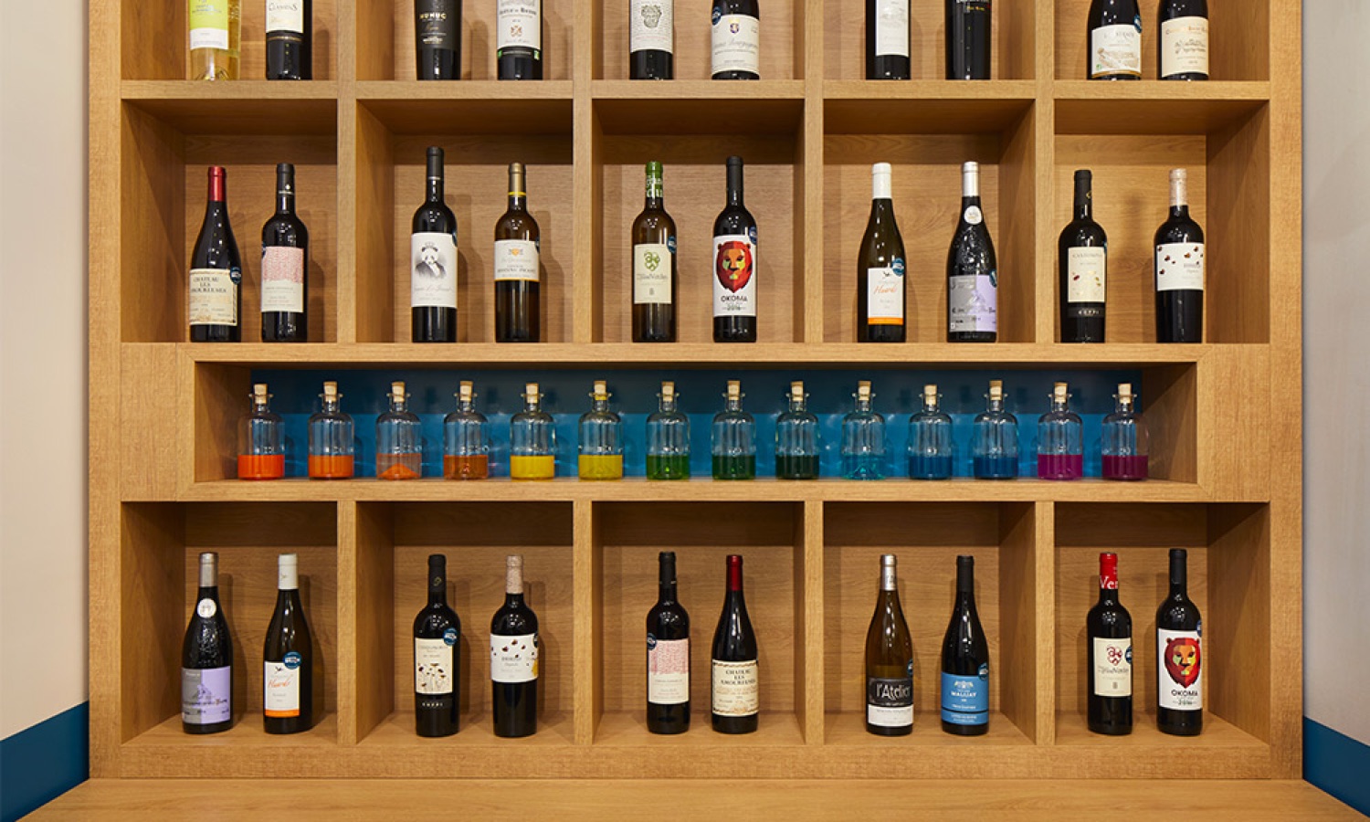 Détail des casiers bois et fioles de dégustation colorées, menuiserie sur mesure Le Petit Ballon