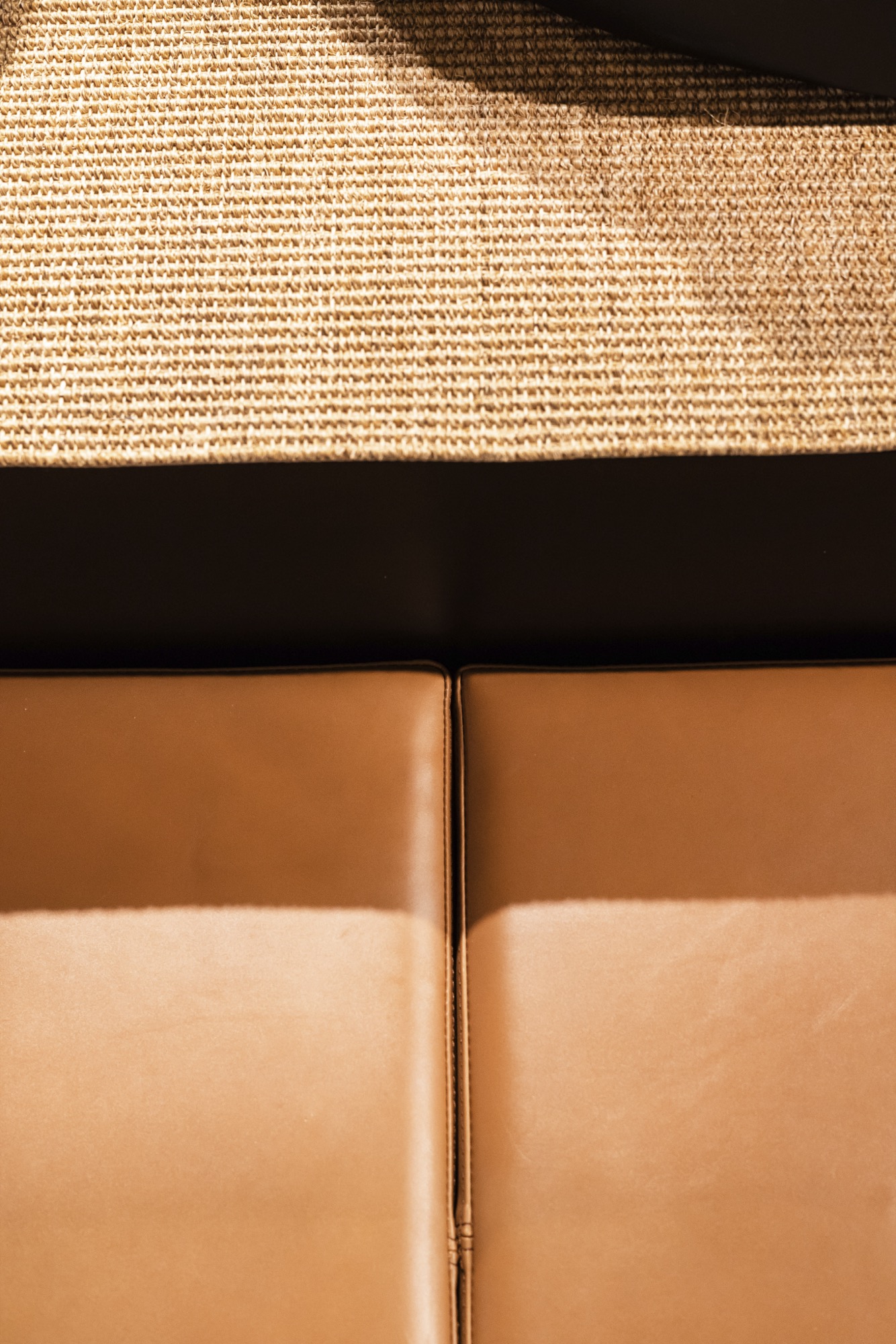 Détail du banc d'essayage en cuir cognac surpiqué