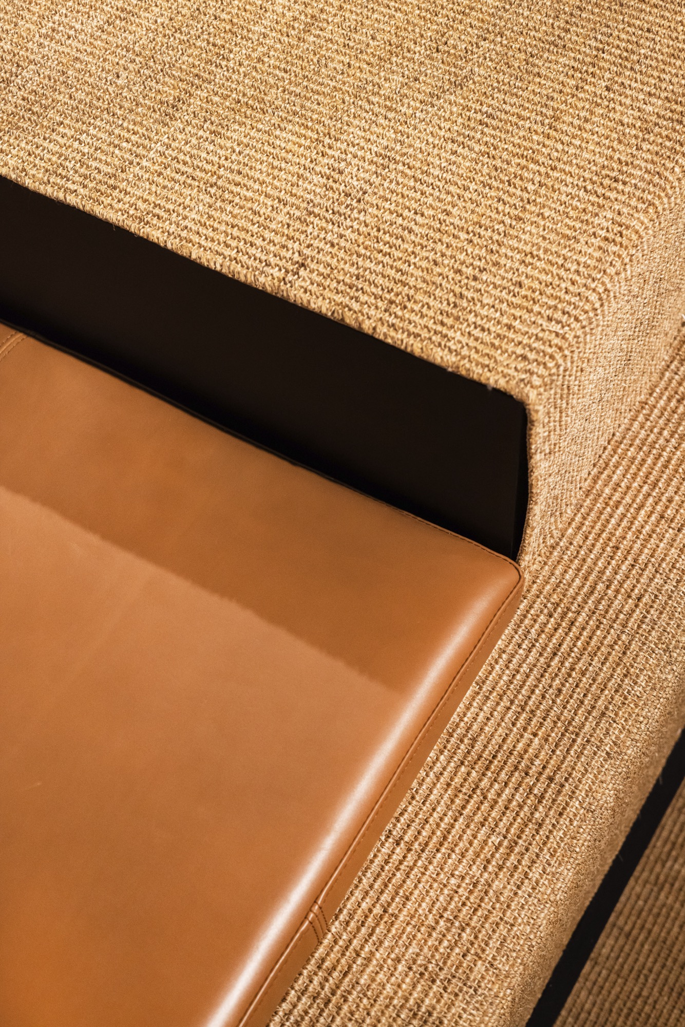 Gros plan sur le plateau de présentation en sisal et le cuir cognac