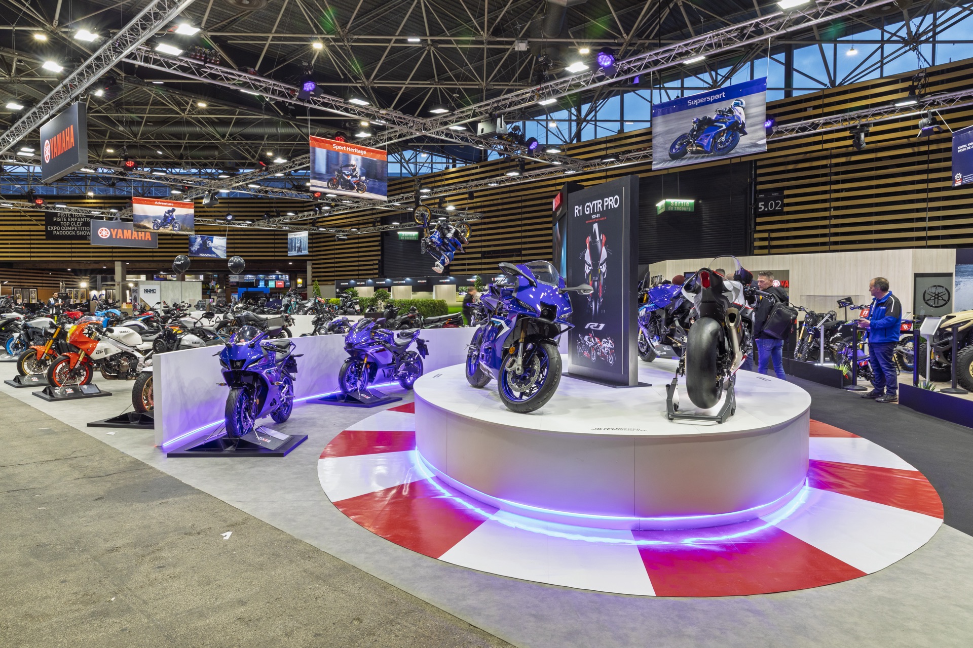 Podium circulaire éclairé mettant en valeur une moto sportive Yamaha