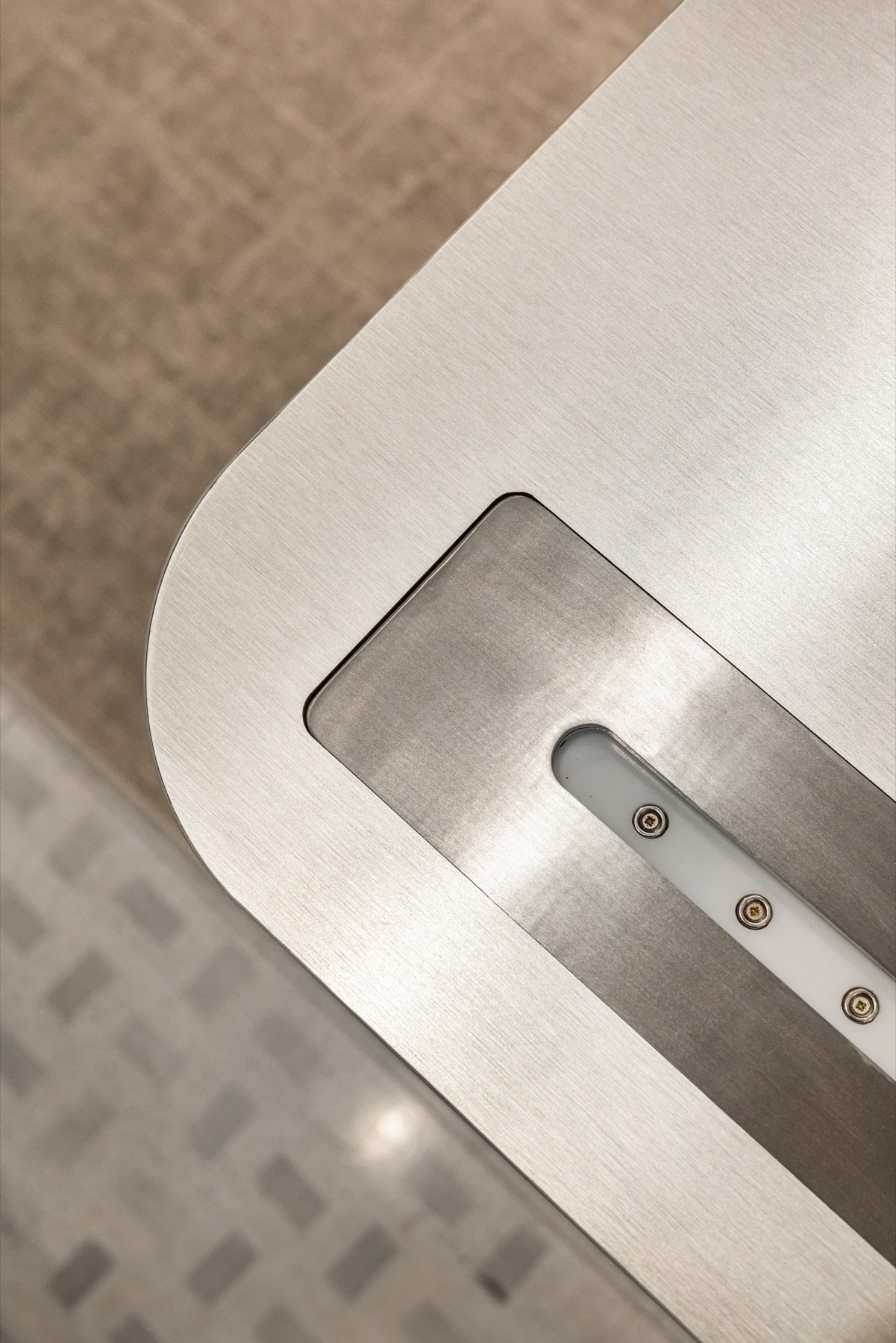 Détail d'angle du plateau en aluminium brossé de la coiffeuse sur mesure