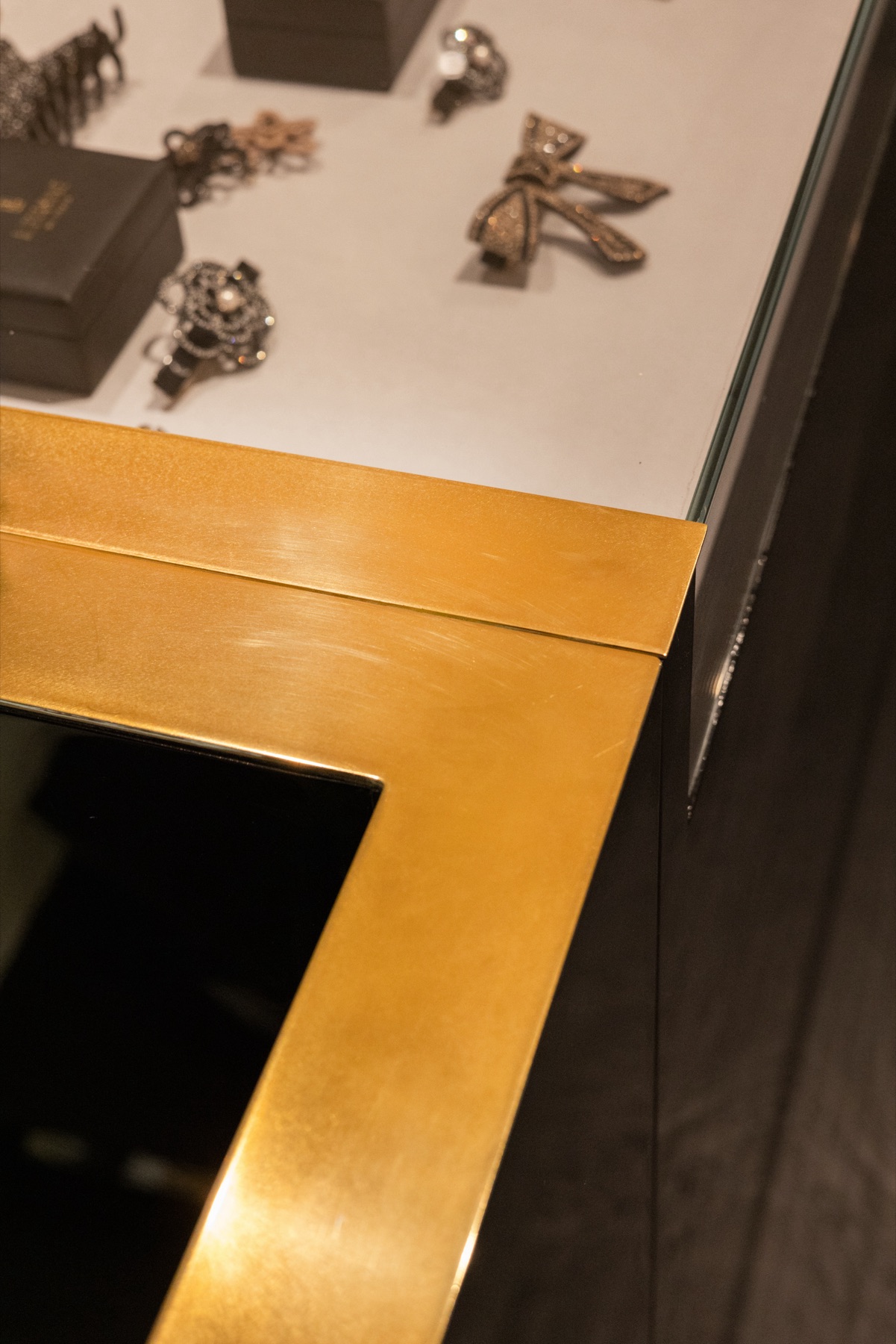 Détail d'une vitrine de présentation en verre et laiton, agencement sur mesure