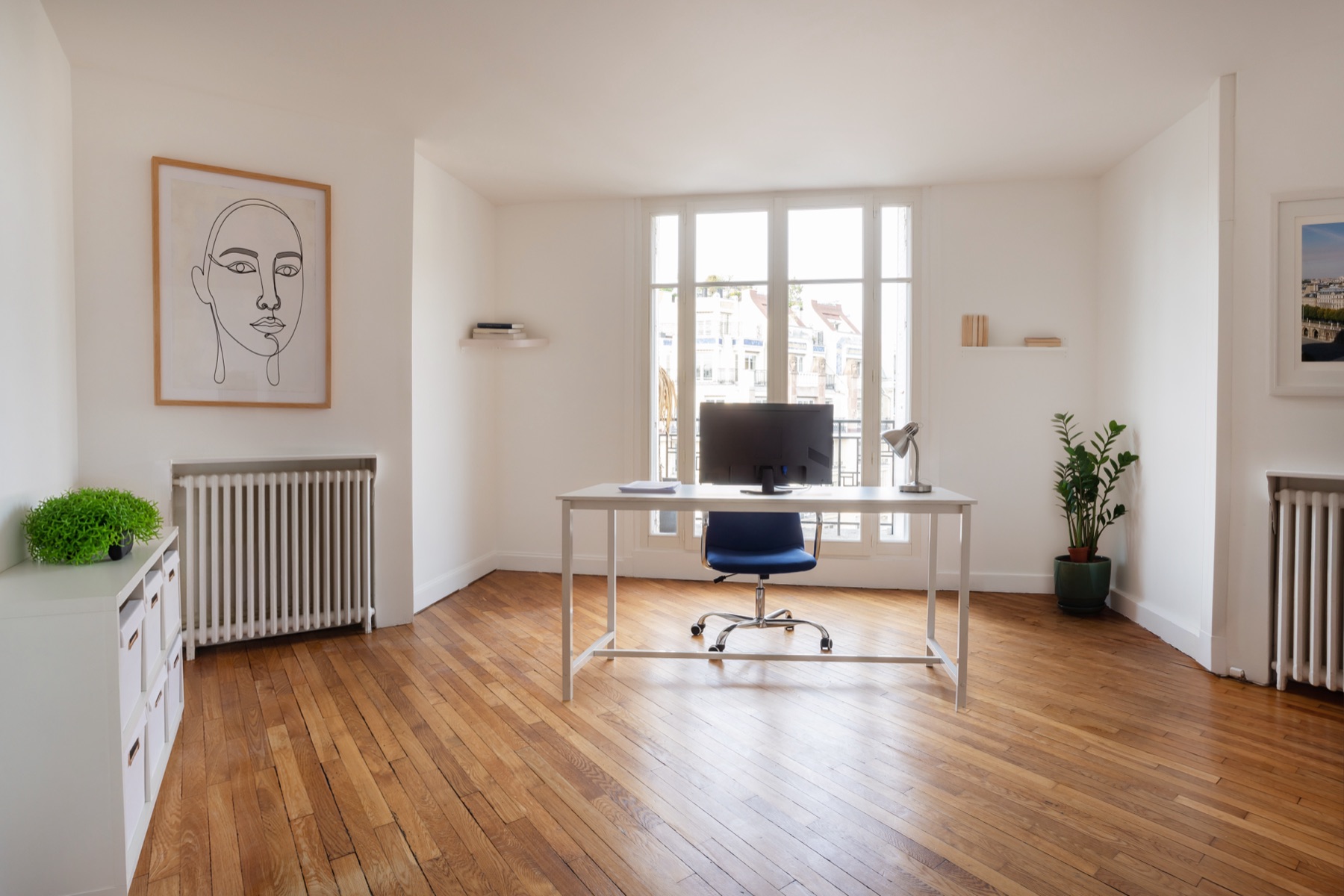 Bureau individuel Act Beauty sous les fenêtres, radiateur en fonte et parquet de chêne