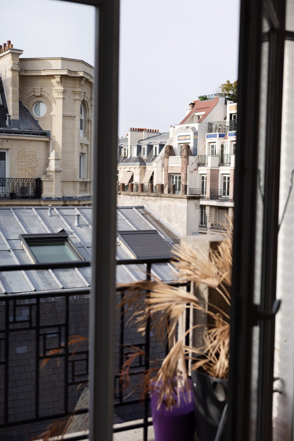 Vue sur les toits haussmanniens depuis une fenêtre des bureaux Act Beauty