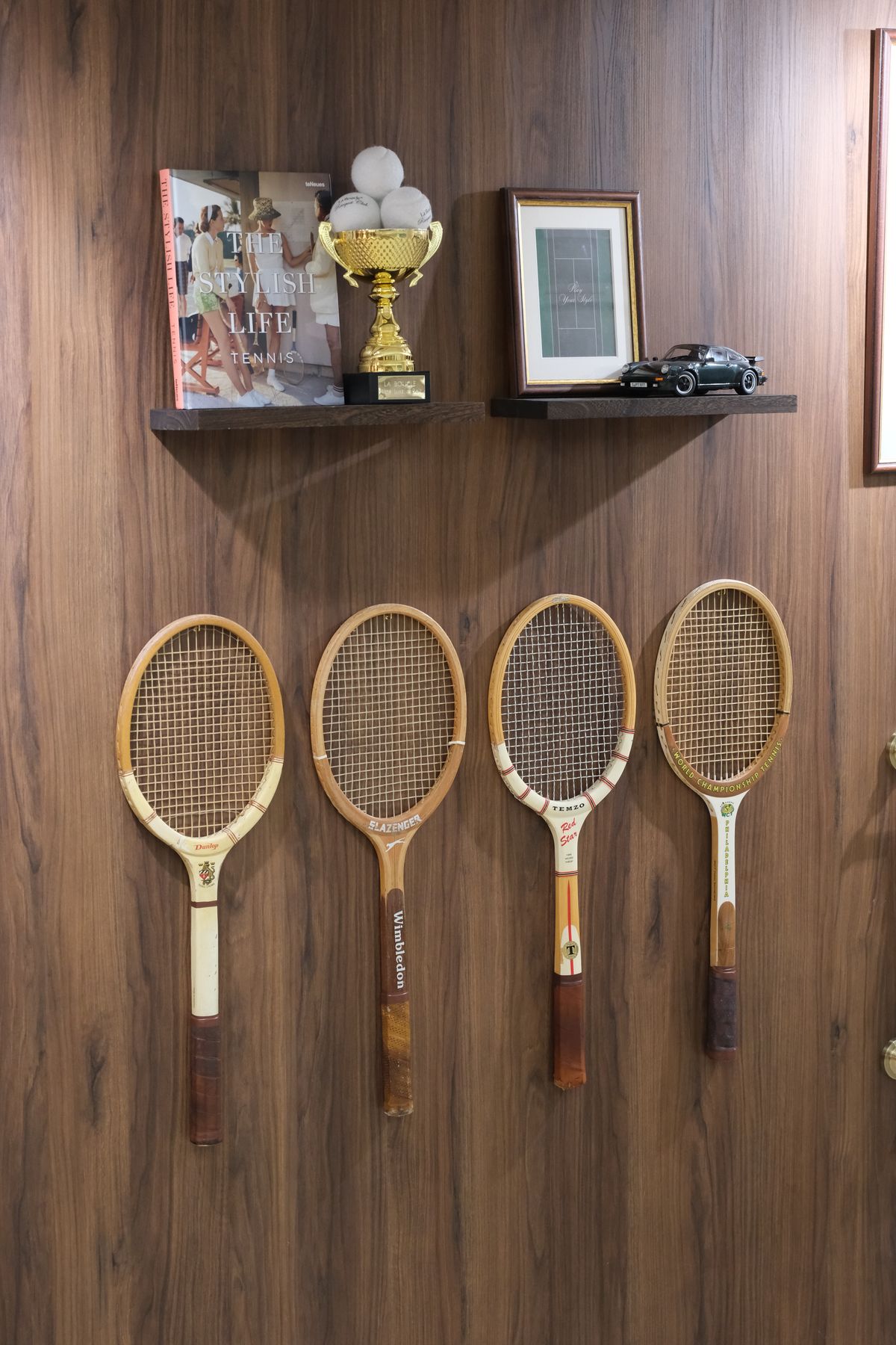 Quatre raquettes de tennis vintage accrochées au mural en décor noyer